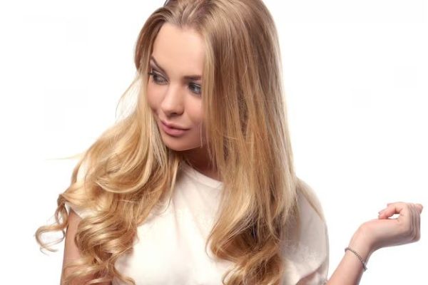 Une blonde séduisante en chemise blanche regarde de côté
