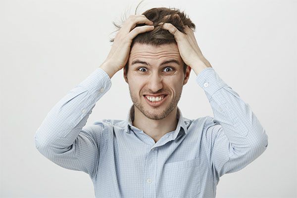 Homme stressé s'agrippant à ses cheveux. Pourquoi nos cheveux s'affaiblissent