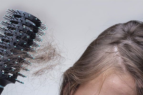 Brosse avec les restes de cheveux d'une femme. cheveux s'affaiblissent