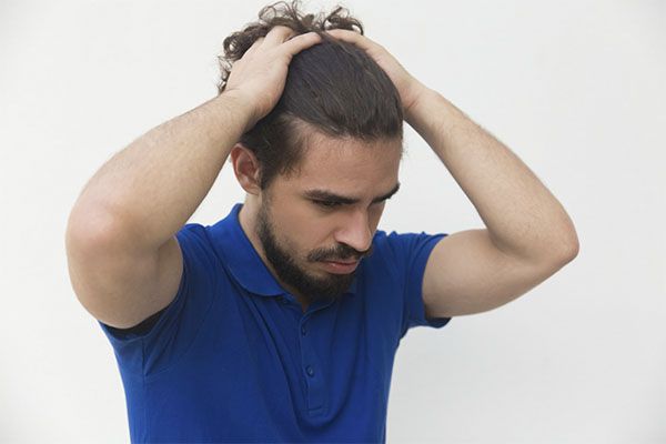 Homme se tenant les cheveux dans les mains