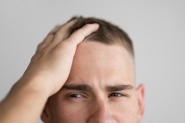 Homme avec la main sur le cuir chevelu, L’automne et la perte de cheveux