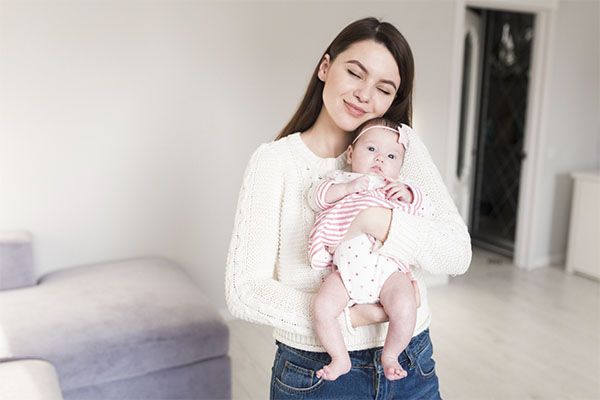 Une belle femme avec un bébé dans les mains.