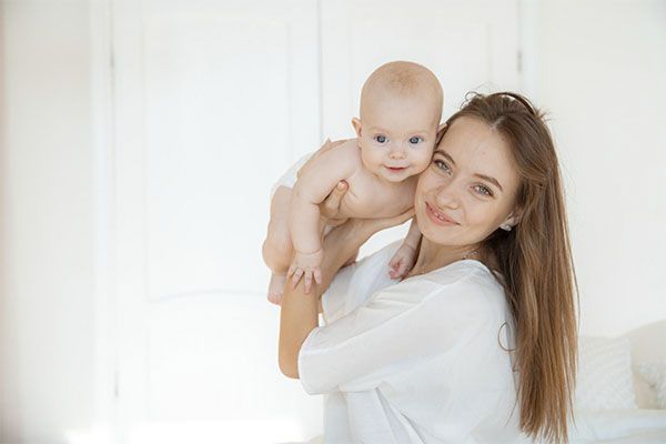 Une belle femme avec un bébé dans les mains.