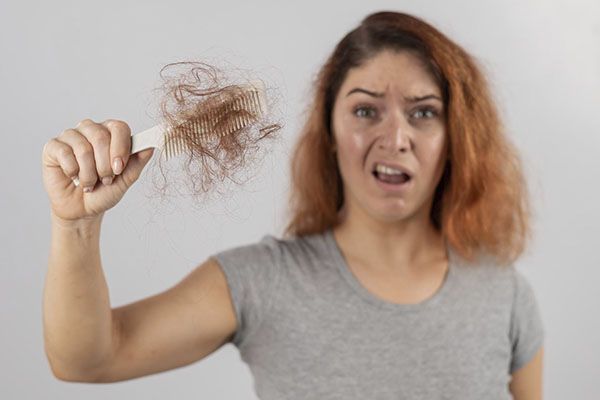 Une femme inquiète parce qu'elle souffre d'une perte de cheveux,, Pourquoi les jeunes femmes perdent-elles leurs cheveux ?
