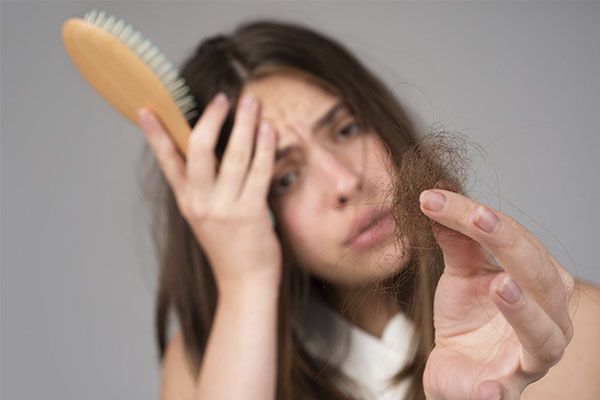 Une femme inquiète parce qu'elle souffre d'une perte de cheveux
