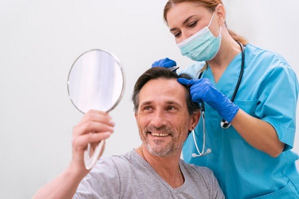 Homme adulte recevant un traitement contre la perte de cheveux.