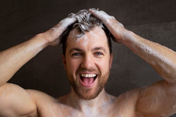 Vue de face homme se lavant les cheveux