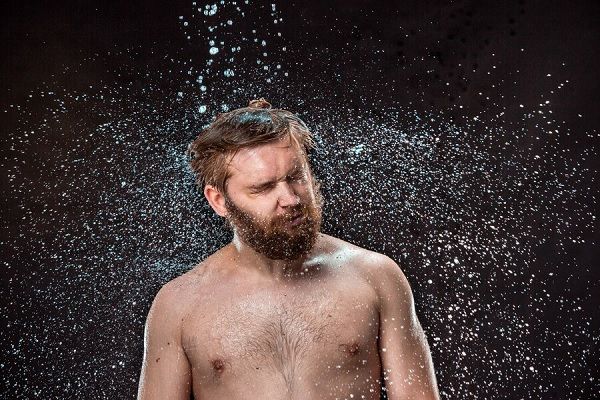 L'éclaboussure d'eau sur le visage masculin. Shampooing au kétoconazole