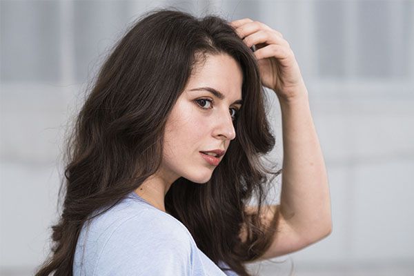 Femme sensuelle caressant des cheveux bruns