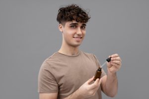 Jeune homme tenant un flacon de solution saline