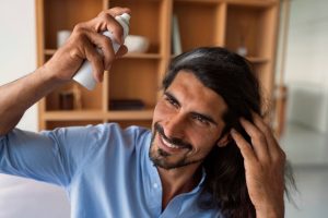 Plan moyen d'un homme utilisant un shampoing sec à la maison