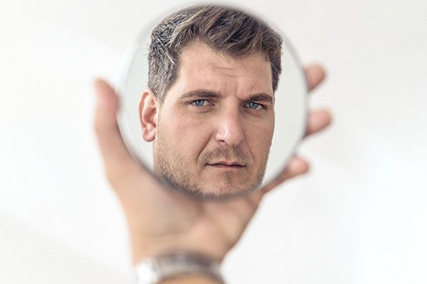 bel homme adulte se regardant dans le miroir. Santé mentale hommes cheveux