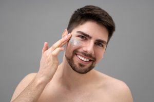 Jeune femme appliquant une lotion scintillante sur son visage