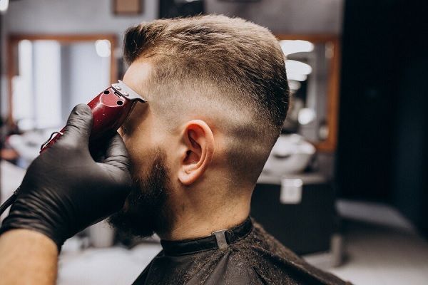 Client faisant une coupe de cheveux dans un salon de coiffure. 