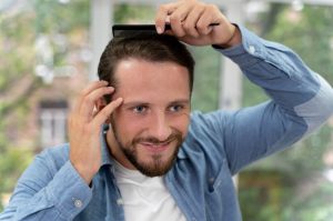 Homme adulte se brossant les cheveux