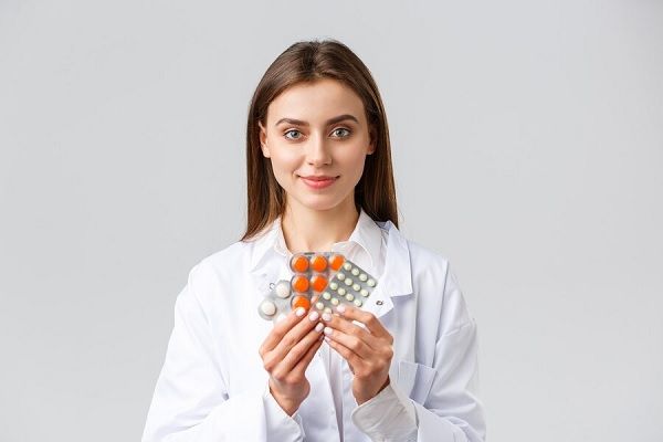 Portrait en gros plan de son joli médecin professionnel qualifié tenant la spironolactone dans les mains. spironolactone pour l'alopécie féminine
