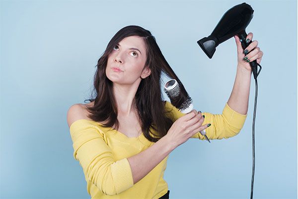 Fille brune se séchant les cheveux