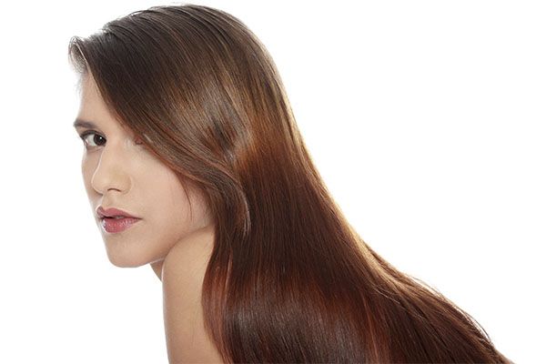 Femme aux longs cheveux bruns sur fond blanc - cheveux sains à l'intérieur