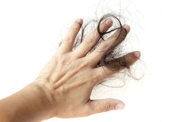 Main d'homme avec des mèches de cheveux