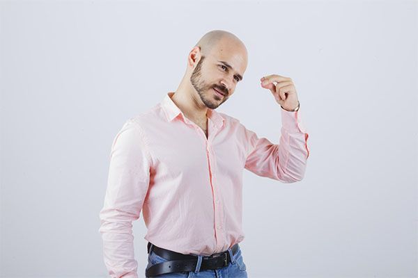 Homme à la chemise rose ayant des problèmes de calvitie