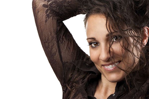 Belle femme en chemise noire et cheveux noirs bouclés.