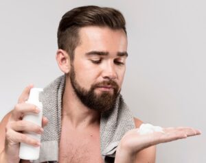 Vue de face d'un homme utilisant de la crème à raser