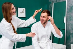Femme en peignoir brossant les cheveux d'un homme