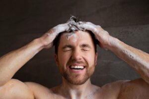 Vue de face d'un homme se lavant les cheveux,Un remède naturel contre la chute des cheveux