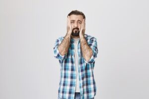 Homme sombre et inquiet se tenant les mains dans un visage désespéré