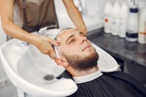 Woma lave la tête de l'homme dans un salon de coiffure
