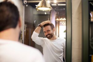 Un jeune homme chez le coiffeur après s'être fait couper les cheveux.