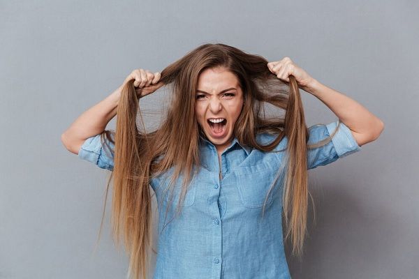 Femme en chemise tenant ses cheveux