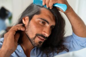 Plan moyen d'un homme utilisant du shampoing sec à la maison.