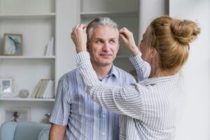 Vue de face d'une femme arrangeant les cheveux de son mari