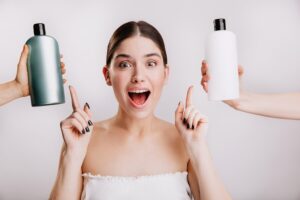 Portrait en gros plan d'une jeune fille joyeuse posant sans maquillage sur un mur blanc. Une femme choisit le meilleur shampoing à utiliser. meilleurs shampoings pour cheveux gras